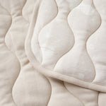 Close-up of a beige quilted fabric with  pattern