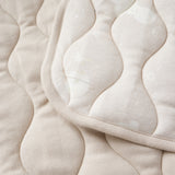 Close-up of a beige quilted fabric with  pattern