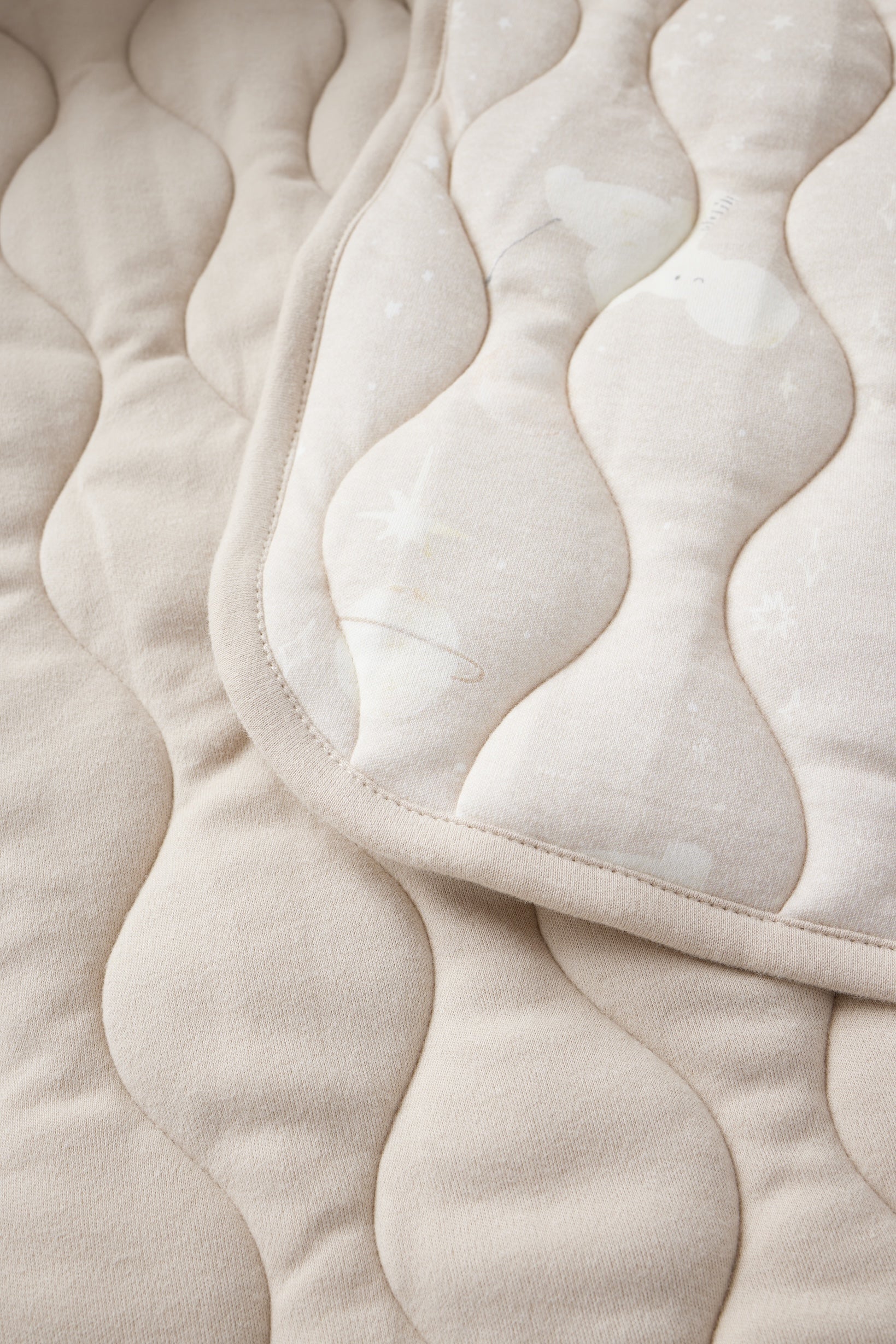 Close-up of a beige quilted fabric with  pattern