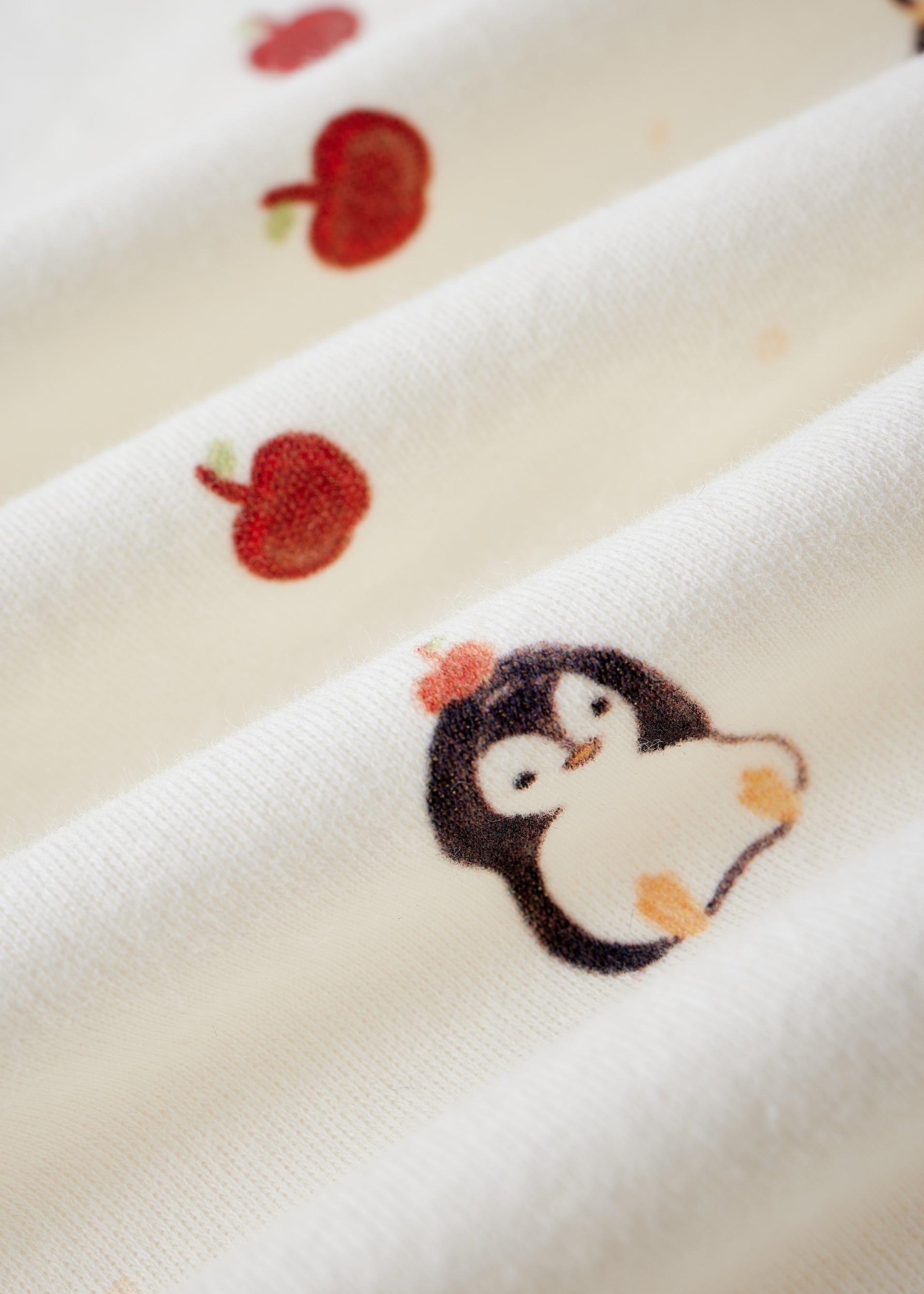 Embroidered penguin design on a white fabric background