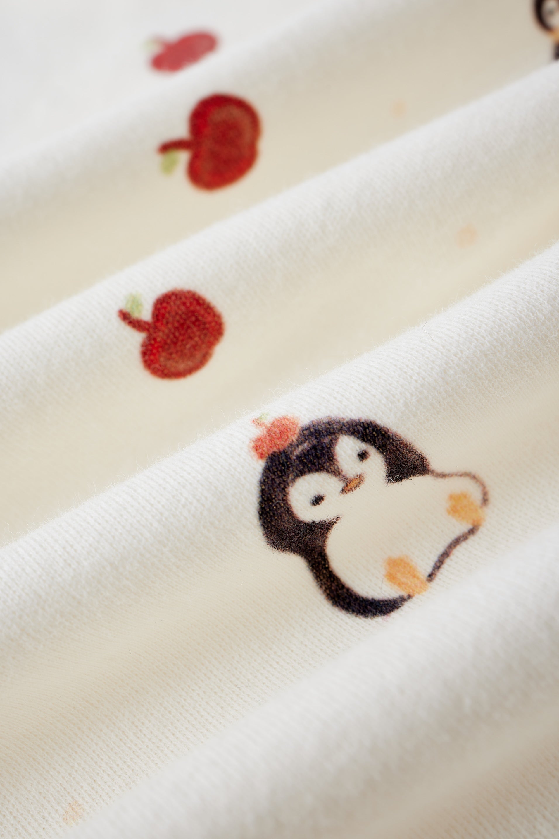 Embroidered penguin design on a white fabric background