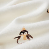 Close-up of a white fabric with small penguin illustrations.