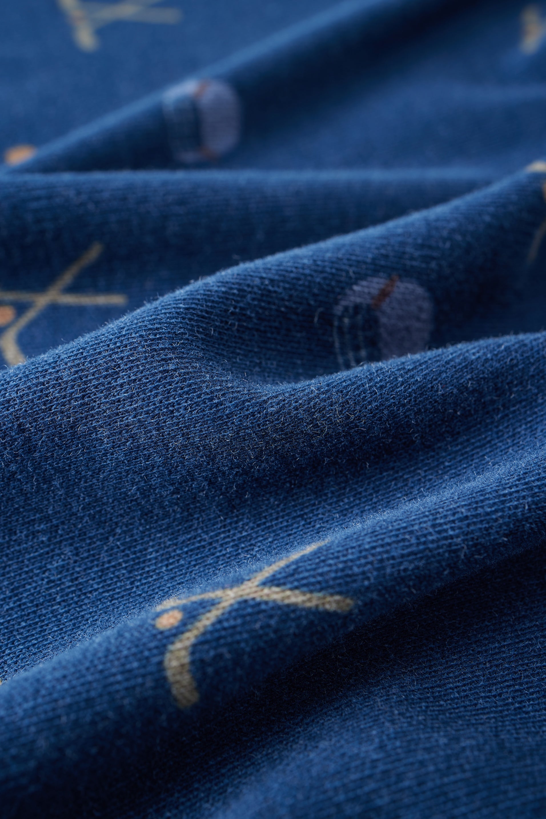 Close-up of blue fabric with gold embroidery