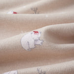 Close-up of beige fabric with embroidered polar bears and plants.