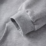 Close-up of a gray sweatshirt with a brand logo on the sleeve.