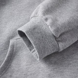 Close-up of a gray sweatshirt with a brand logo on the sleeve.