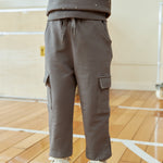 Person wearing a gray sweatshirt and cargo pants on a wooden floor.