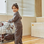 Child pushing a cart with sports balls in a gymnasium
