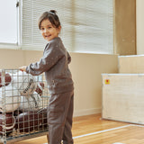 Child pushing a cart with sports balls in a gymnasium
