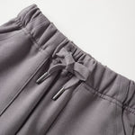 Gray pants with drawstring and brand logo on a light gray background