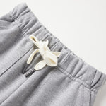 Gray sweatpants with a decorative bow on a light gray background