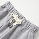 Gray sweatpants with a decorative bow on a light gray background
