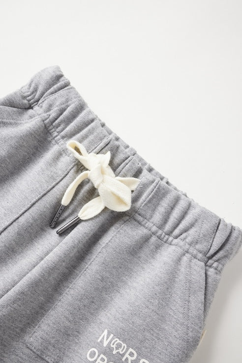 Gray sweatpants with a decorative bow on a light gray background