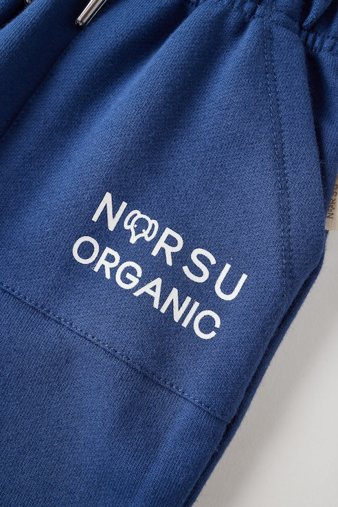 Blue fabric with 'NORSU ORGANIC' text on a neutral background