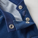 Close-up of a blue garment with buttons on a light gray background