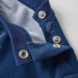 Close-up of a blue garment with buttons on a light gray background