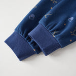 Close-up of blue fabric with embroidered designs on a light gray background