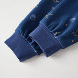 Close-up of blue fabric with embroidered designs on a light gray background