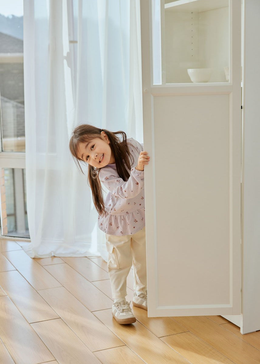 baby girl stand behind the door