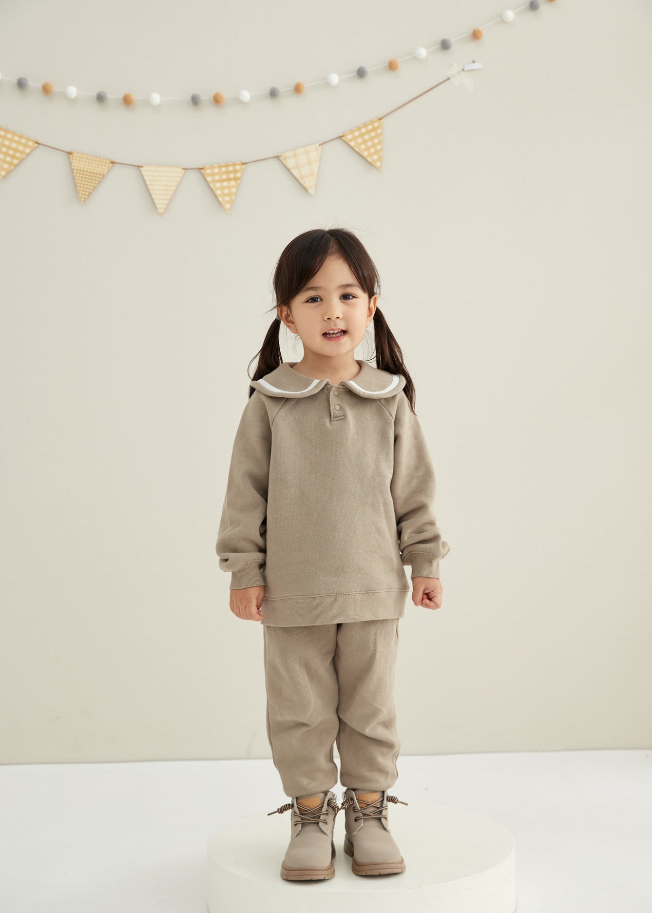 baby girl is standing and smiling 