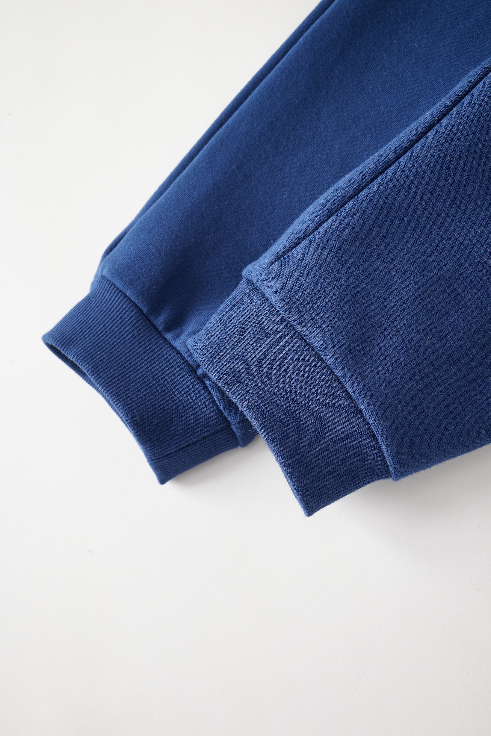 Close-up of a blue sweapant on a light gray background