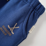 Blue sweatpants with hocket print and text on a light gray background