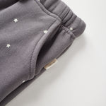 Gray sweatpants with star patterns on a light gray background