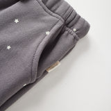 Gray sweatpants with star patterns on a light gray background