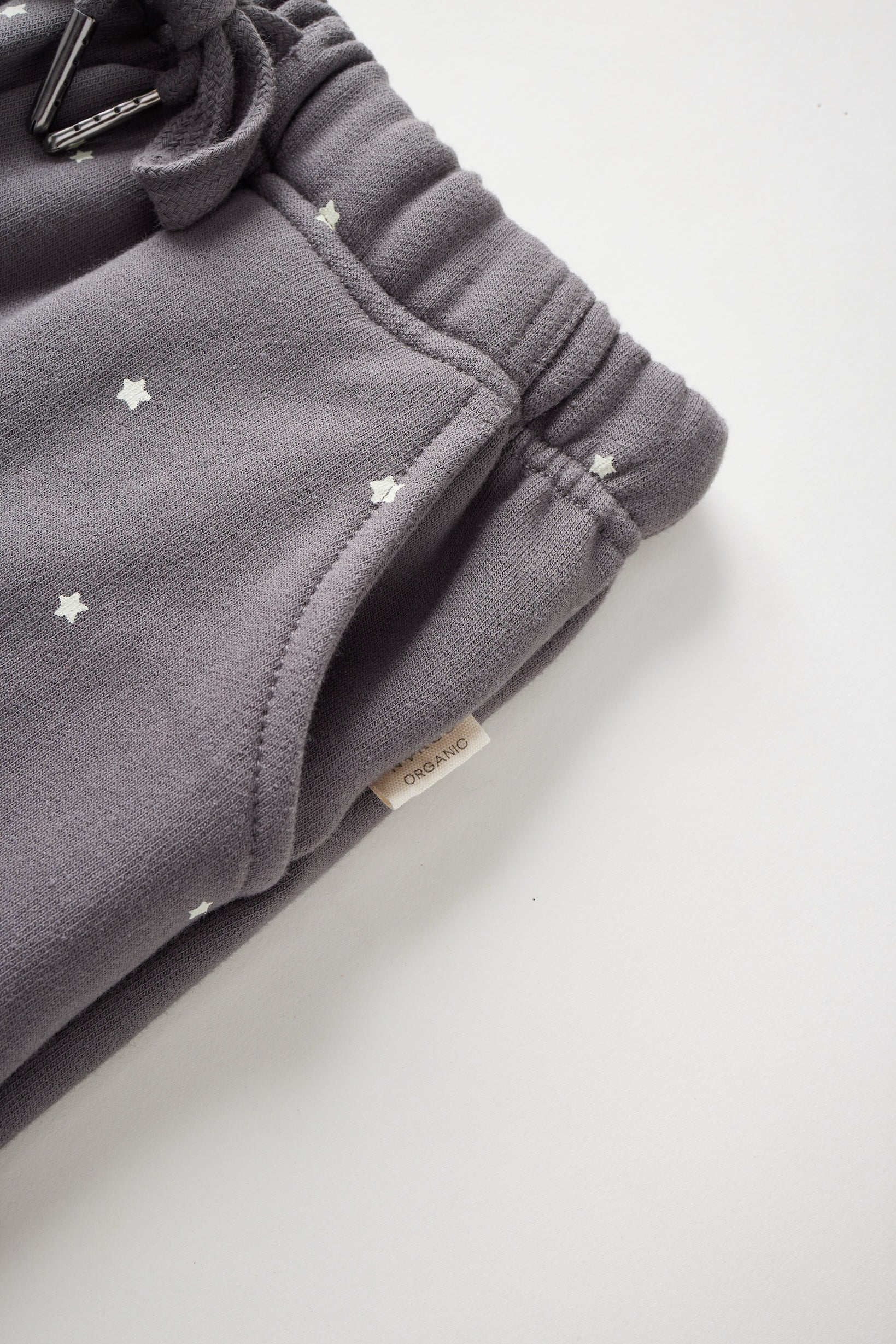 Gray sweatpants with star patterns on a light gray background