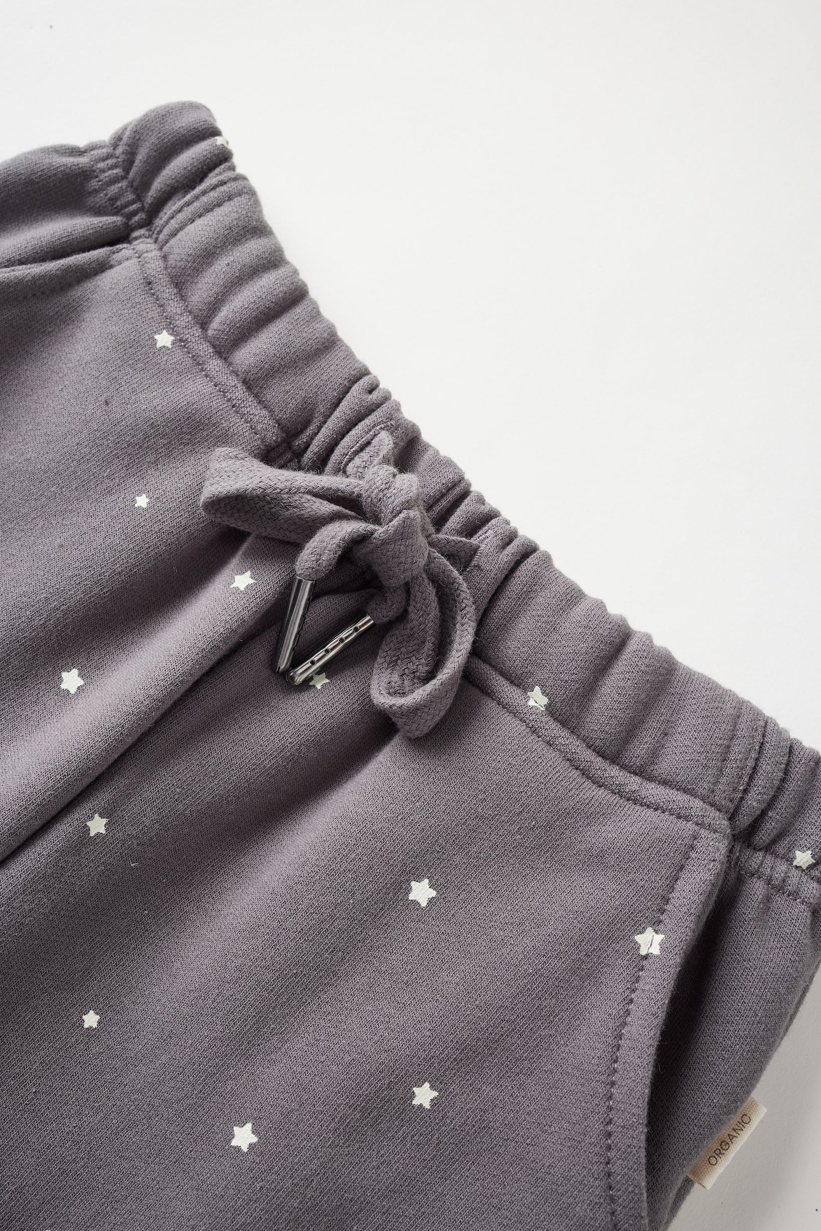 Gray sweatpants with star patterns on a light gray background