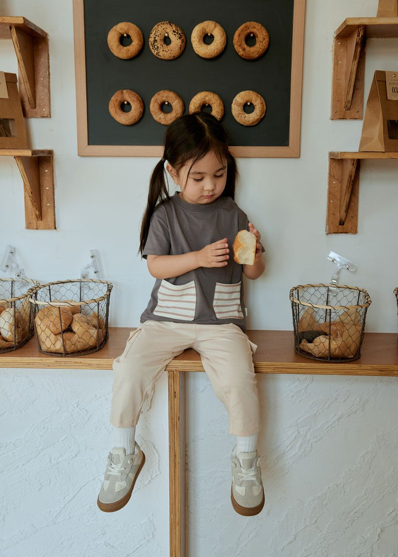 baby girl looking at here bread and sitting on the table