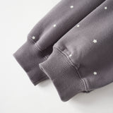 Gray sweatshirt with star patterns on a light gray background