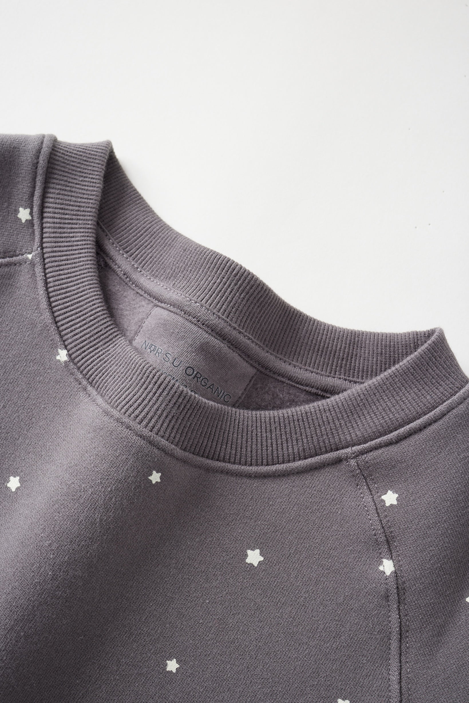 Dark gray sweatshirt with star patterns on a light gray background