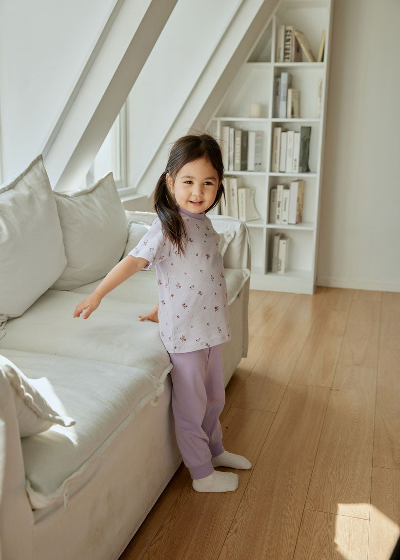 baby girl is standing beside the sofa