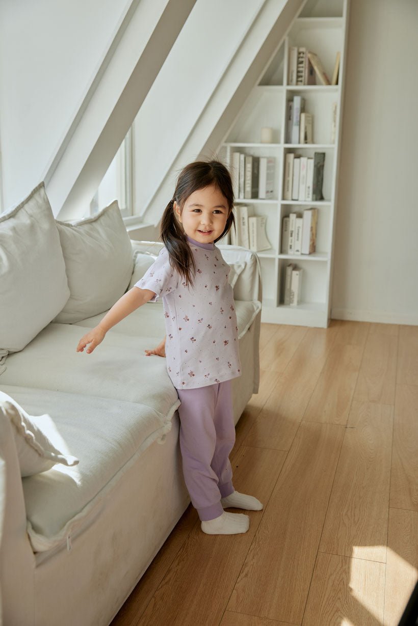 baby girl is standing beside the sofa