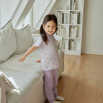 baby girl is standing beside the sofa