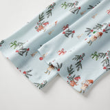 Two folded fabric swatches with a festive pattern on a light background