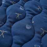 Close-up of blue blanket with embroidered designs on a textured surface