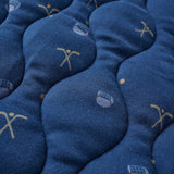 Close-up of blue blanket with embroidered designs on a textured surface