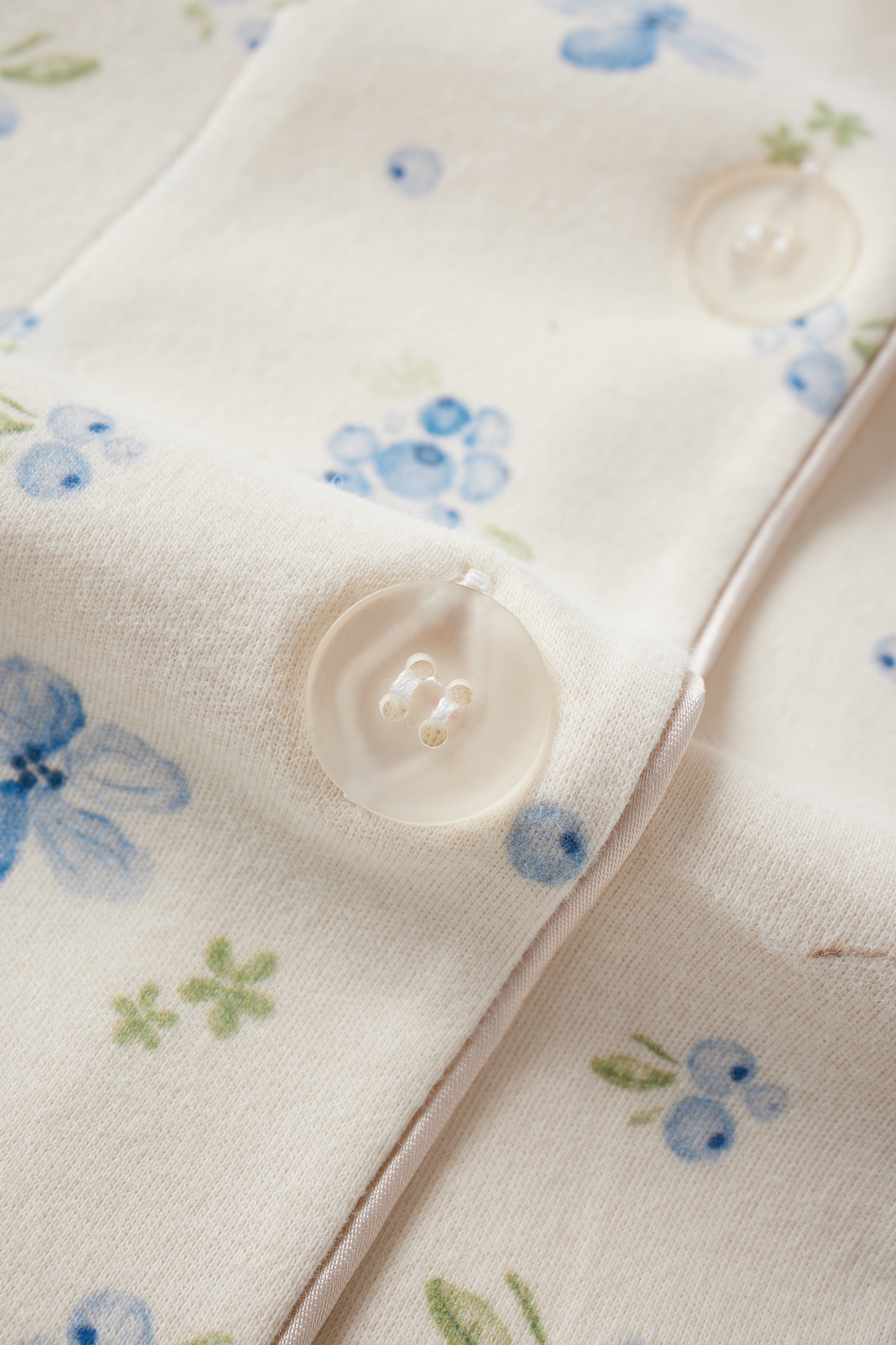 Close-up of a fabric with floral patterns and buttons.