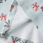 Christmas-themed fabric with reindeer, holly, and presents on a white background