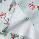 Christmas-themed fabric with reindeer, holly, and presents on a white background