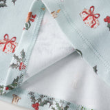 Christmas-themed fabric with reindeer, holly, and presents on a white background
