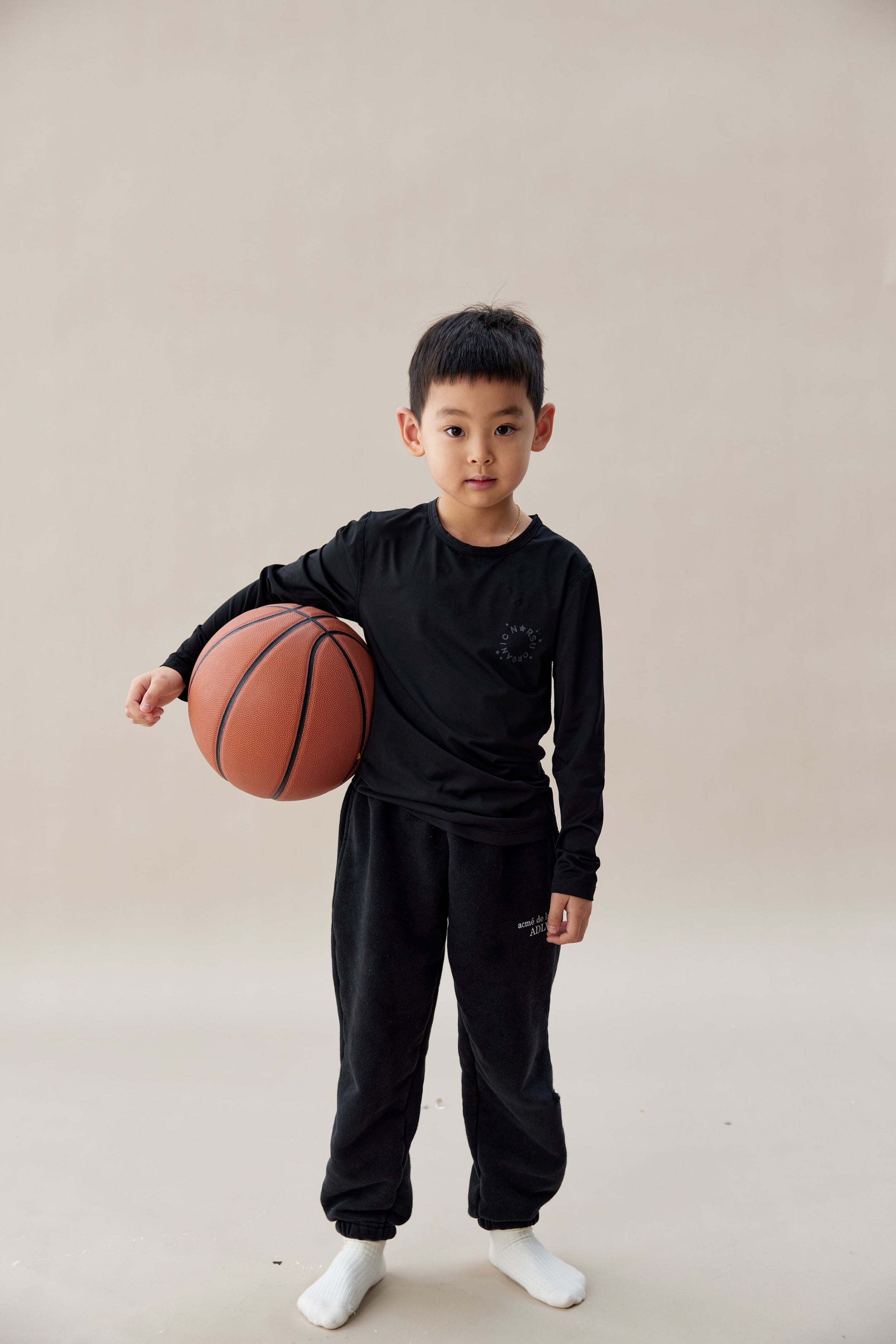 Child holding a basketball against a plain background