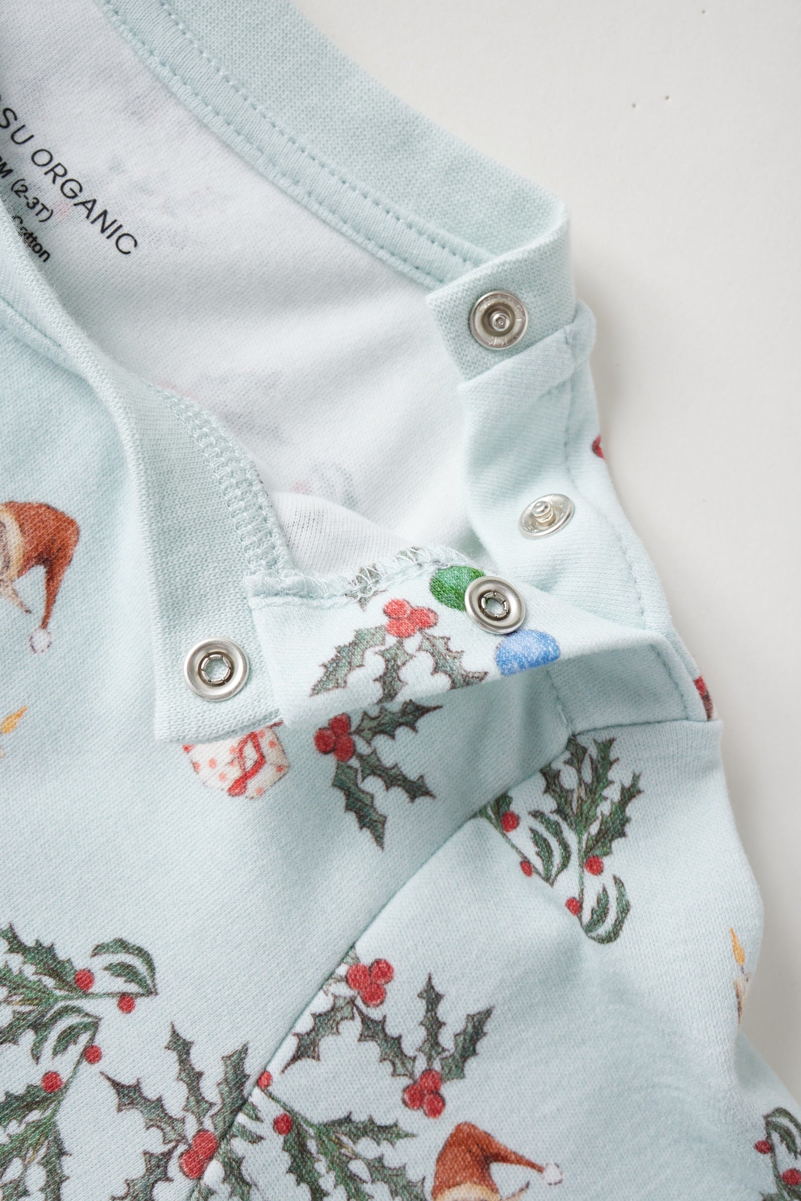 Light blue shirt with Christmas-themed pattern on a white background