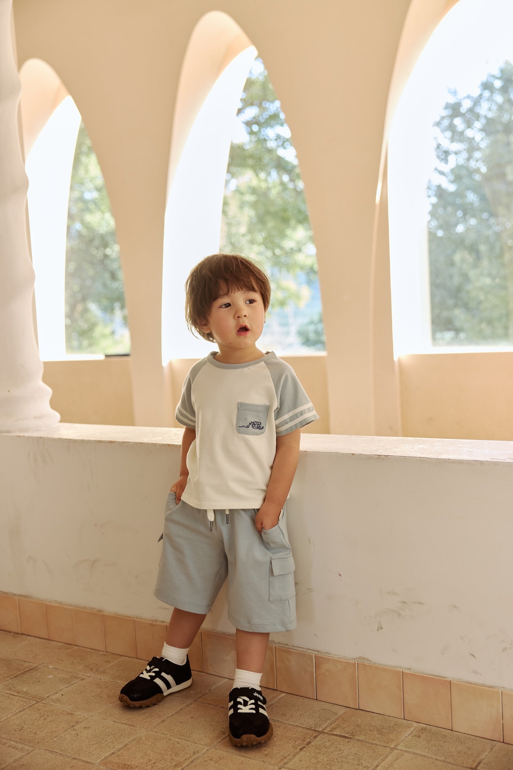 Toddler wearing light blue cargo shorts and a summer t-shirt